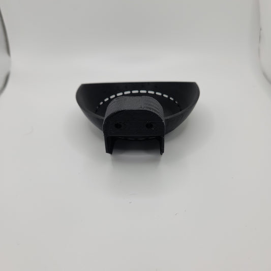 A close-up image of a black 3D-printed Echo Dot holder viewed from the back. The holder has a semi-circular base with a slot at the back designed to accommodate an Echo Dot device. The surface is smooth, and there are two small holes near the top for mounting.